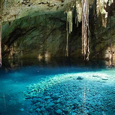 Тюркоазен басейн с вода блести в пещера. Цветът е причинен от фино смлени минерали, разпръснати във водата.